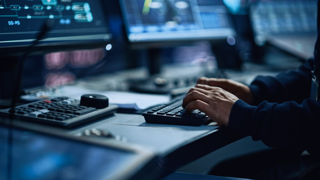 Close Up of a Professional Office Specialist Working on Desktop Computer in Modern Technological Monitoring Control Room with Digital Screens. Manager Typing on keyboard and Using Mouse